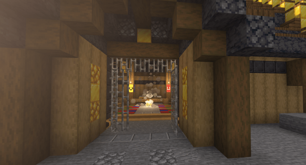 A close up of the main door. The wooden doors have golden details in them, and behind those are two open iron grated gates. Within is a carpeted room lit by a central campfire and hanging lanterns.