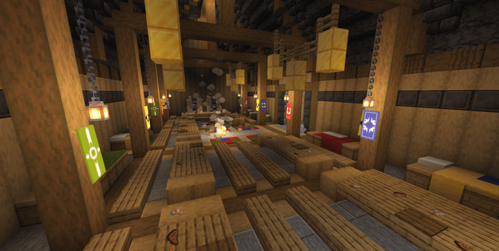 Interior shot. The stone and wood floor is covered in tables and benches. more benches are along the sides of the hall, set behind the interior supports, covered in colorful bedding. The tables all have food on them, and at the end of the hall is a head table with two big chairs. Banners hang from the supports and golden tapestries hang from the rafters.