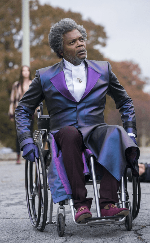 Samuel L. Jackson as Mr. Glass as depicted in Unbreakable by M. Night Shyamalan, in a wheelchair and a purple coat and outfit.