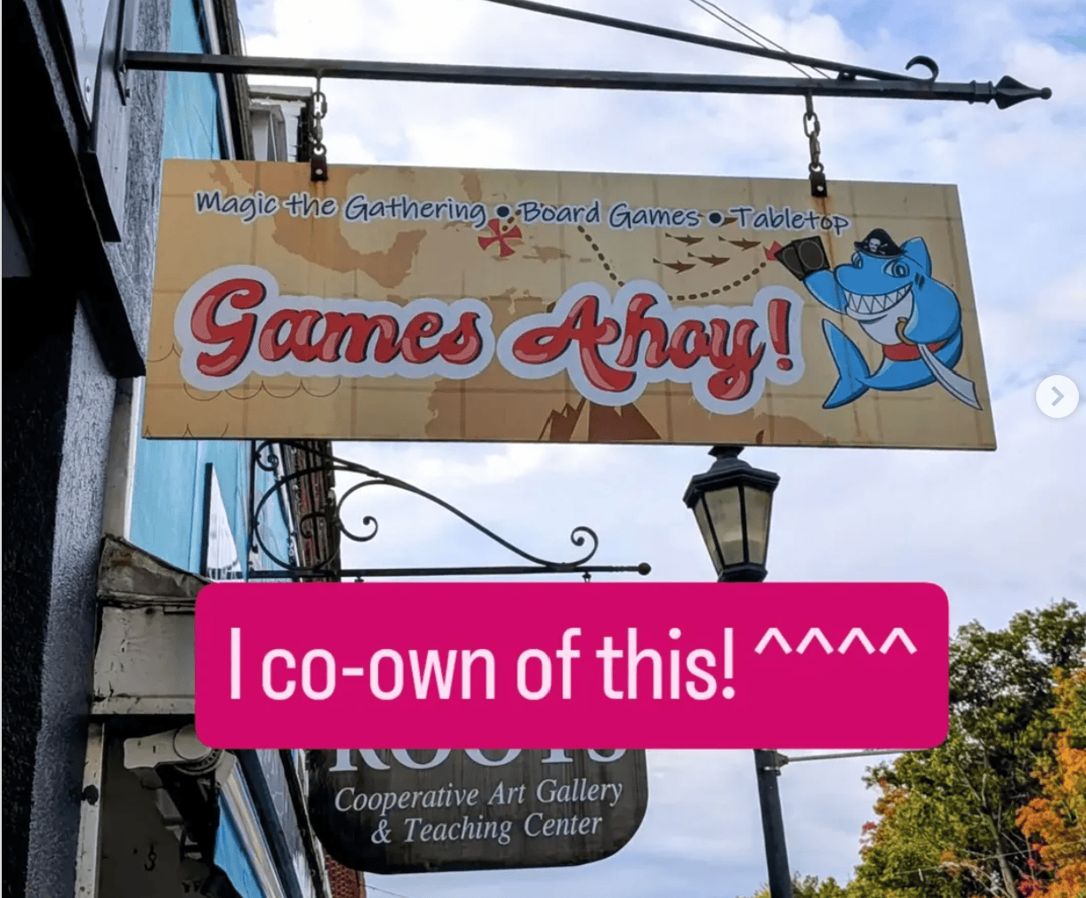 Picture of the sign of 'Games Ahoy', a local game store, with the caption "I co-own this!"